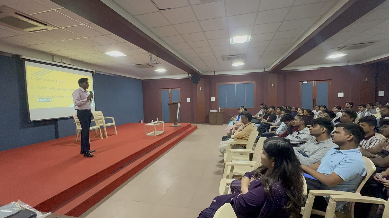 Akash Kamble presenting to a full auditorium at a college workshop